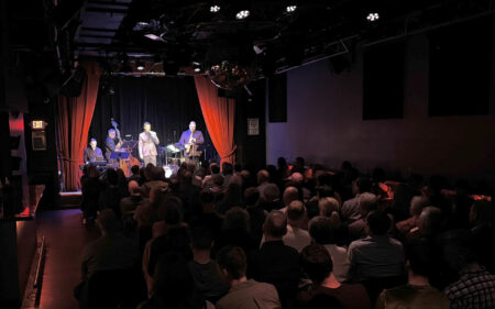 Frankie Campofelice performs on the Moonshine Room stage with theatre style seating arrangement.